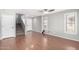 Bright living room showcasing hardwood floors, large windows, and a staircase leading to the upper level at 11455 E Persimmon Ave, Mesa, AZ 85212