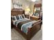 Bedroom with decorative furniture, carpeted floors, and a large wooden bed with nice linens at 12027 W Morning Dove Dr, Sun City, AZ 85373