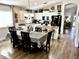 Open concept kitchen featuring white cabinetry, black appliances, and a dining area with table at 12027 W Morning Dove Dr, Sun City, AZ 85373