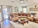 Spacious living room featuring a large sectional sofa, an open door, and natural light at 12027 W Morning Dove Dr, Sun City, AZ 85373