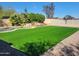 Lush backyard featuring artificial turf, waterfall feature, mature trees, and space for entertaining at 12210 N 67Th St, Scottsdale, AZ 85254
