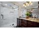 Elegant bathroom featuring a glass-enclosed shower and a marble-topped wooden vanity with dual sinks at 12210 N 67Th St, Scottsdale, AZ 85254