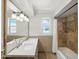 Well-lit bathroom boasts dual sinks, decorative tile, and shower over tub at 12210 N 67Th St, Scottsdale, AZ 85254