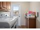Bright laundry room with white appliances and ample cabinet space above the counter at 12210 N 67Th St, Scottsdale, AZ 85254
