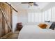 Bright main bedroom features a sliding barn door, white plantation shutters and ceiling fan at 12210 N 67Th St, Scottsdale, AZ 85254