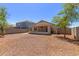 Backyard with an enclosed patio, mature trees, privacy fence, and gravel ground cover at 12438 W Flores Dr, El Mirage, AZ 85335