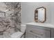 Modern bathroom features a stylish sink, toilet, and shower with elegant marble-like tiling at 12438 W Flores Dr, El Mirage, AZ 85335