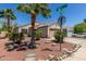 Well-kept single-story home with desert landscaping, mature trees, and a two-car garage at 12438 W Flores Dr, El Mirage, AZ 85335