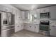 Modern kitchen with stainless steel appliances and light gray cabinetry at 12438 W Flores Dr, El Mirage, AZ 85335