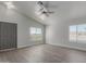 Bright living room with vaulted ceilings, neutral paint, and plank flooring at 12438 W Flores Dr, El Mirage, AZ 85335