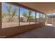 Covered patio with a view of the spacious backyard surrounded by a block fence at 12438 W Flores Dr, El Mirage, AZ 85335