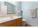 Bright bathroom with light blue walls, a vanity sink, toilet, and shower at 1350 S Greenfield Rd # 1040, Mesa, AZ 85206