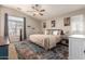 Spacious primary bedroom with ceiling fan, stylish rug and large window at 1350 S Greenfield Rd # 1040, Mesa, AZ 85206