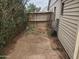 Narrow dirt backyard with a wooden fence and an overgrown bush lining the wall at 1363 E Clarendon Ave, Phoenix, AZ 85014