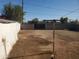 Fenced in dirt backyard with clear sky, surrounded by a block wall fence at 1363 E Clarendon Ave, Phoenix, AZ 85014