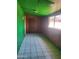 Room with wood paneled walls and green paint with tile flooring and a wood door at 1363 E Clarendon Ave, Phoenix, AZ 85014