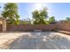 Expansive backyard featuring a concrete patio area and brick perimeter wall under a sunny sky at 14440 W Cholla St, Surprise, AZ 85379