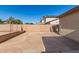 Backyard with a stone patio, bordered by a block wall and fence, offering space and privacy at 14440 W Cholla St, Surprise, AZ 85379