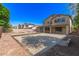 Wide backyard with a cement patio, partial pool fence, and an open lawn for outdoor activities at 14440 W Cholla St, Surprise, AZ 85379
