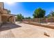 Spacious backyard with a stone patio, a sparkling pool, covered patio, and lush landscaping at 14440 W Cholla St, Surprise, AZ 85379