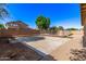 Large backyard with a cement patio area, partial pool fence, and greenery enhancing privacy at 14440 W Cholla St, Surprise, AZ 85379