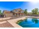Inviting backyard featuring a sparkling pool, patio area, and lush landscaping, perfect for relaxing at 14440 W Cholla St, Surprise, AZ 85379