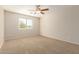 Bedroom with a large window providing natural light and neutral colored walls and carpet at 14440 W Cholla St, Surprise, AZ 85379