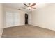 Bedroom with neutral walls, carpeted floor, ceiling fan, closet and doorway to another room at 14440 W Cholla St, Surprise, AZ 85379