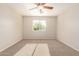 This cozy carpeted bedroom features a ceiling fan and a window offering natural light at 14440 W Cholla St, Surprise, AZ 85379