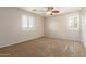 Bedroom with plush carpet, ceiling fan, and plantation shutters at 14440 W Cholla St, Surprise, AZ 85379