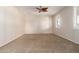 Spacious bedroom with neutral walls, carpeted floors, window with plantation shutters, and ceiling fan at 14440 W Cholla St, Surprise, AZ 85379