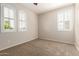 A well-lit bedroom features carpet, shuttered windows, and a ceiling fan at 14440 W Cholla St, Surprise, AZ 85379
