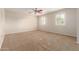 Bright bedroom with neutral walls, plush carpet, ceiling fan, and plantation shutters at 14440 W Cholla St, Surprise, AZ 85379