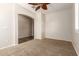 Neutral bedroom with carpet, ceiling fan, and archway at 14440 W Cholla St, Surprise, AZ 85379