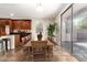 Dining area featuring a large wooden table, access to the patio, and dark wood cabinets at 14440 W Cholla St, Surprise, AZ 85379