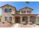 Beautiful home featuring a welcoming front porch, shutters, and attractive landscaping at 14440 W Cholla St, Surprise, AZ 85379