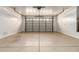 Spacious garage with a roll-up door, bright white walls, and concrete flooring at 14440 W Cholla St, Surprise, AZ 85379