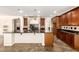 Gourmet kitchen features dark wood cabinets, stone accents, granite countertops, and tile floors, a chef's dream at 14440 W Cholla St, Surprise, AZ 85379