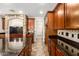 Spacious kitchen showcasing dark wood cabinets, stone accents, granite countertops, and tile floors, perfect for cooking at 14440 W Cholla St, Surprise, AZ 85379
