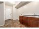 Functional laundry room featuring wood cabinets, tile flooring, and sink at 14440 W Cholla St, Surprise, AZ 85379