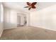 Large vacant living room featuring plush carpet and a ceiling fan at 14440 W Cholla St, Surprise, AZ 85379