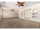 Bright, spacious living room featuring neutral walls, ceiling fans, and a built-in entertainment center at 14440 W Cholla St, Surprise, AZ 85379