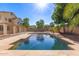 Sparkling pool with rock decking, surrounded by lush greenery, creating a private outdoor oasis at 14440 W Cholla St, Surprise, AZ 85379