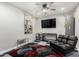 Bonus room has a mounted television, sleek furniture, and decorative artwork at 14809 N El Frio Cir, El Mirage, AZ 85335