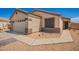 Single story home with a two car garage, desert landscaping, and a driveway with paved walkway at 14809 N El Frio Cir, El Mirage, AZ 85335