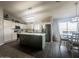 Modern kitchen featuring white cabinetry, stainless steel appliances, a green center island, and an adjacent dining area at 14809 N El Frio Cir, El Mirage, AZ 85335