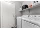 Laundry room featuring a washer, dryer, utility sink and storage shelves above at 14809 N El Frio Cir, El Mirage, AZ 85335