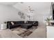 Spacious living room featuring a large sectional sofa, ceiling fan, and modern decor at 14809 N El Frio Cir, El Mirage, AZ 85335