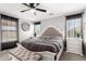 Elegant main bedroom with a decorative headboard, ceiling fan, and soft natural lighting at 14809 N El Frio Cir, El Mirage, AZ 85335