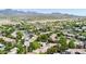 An aerial view of a desert community showcasing tile roofs, lush landscaping, and beautiful mountain views at 15151 N Frank Lloyd Wright Blvd # 1088, Scottsdale, AZ 85260